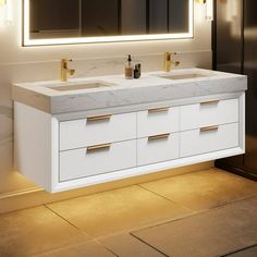 a bathroom vanity with two sinks under a large lighted mirror and lights on the wall