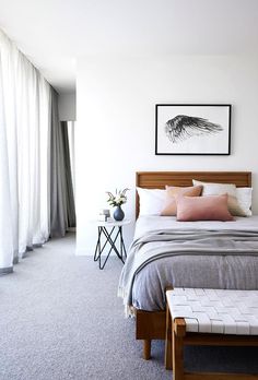 a bed room with a neatly made bed next to a window