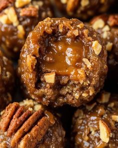 a pile of pecan balls covered in caramel and walnuts with a bite taken out