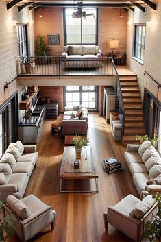 a living room filled with lots of furniture next to a stair case and wooden floors