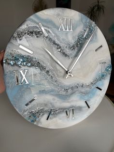 a marble clock with roman numerals on the face and numbers painted on it