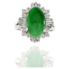 18KT white gold retro era cocktail ring consisting of genuine green jade surrounded by 1.30CT-TW of round brilliant and baguette cut diamonds. A timeless piece featuring luxurious 18KT white gold, genuine green jade, and 1.30CT-TW of high-quality diamonds, perfect for any special occasion. Size 6 US. Weight 7 gm. Retro Era, Jade Ring, Baguette Cut Diamond, Baguette Cut, Green Jade, Jade Green, Quality Diamonds, Cocktail Ring, Cocktail Rings