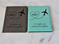 two personalized passport covers with an airplane in the shape of a heart on them