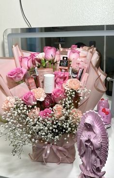 a bouquet of pink roses and baby's breath in a vase next to a mirror