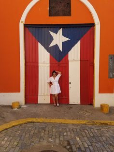 a woman standing in front of a red, white and blue door