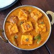 tofu curry in a silver bowl on a wooden table