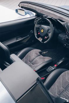 the interior of a sports car with black and grey leather seats, steering wheel and dashboard