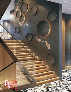 the stairs are decorated with metal circles and fish on them, along with marble flooring