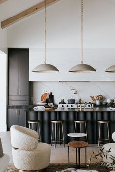 an open kitchen and living room area with chairs, stools, counter tops and cabinets