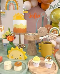 a table topped with lots of cakes and cupcakes