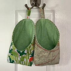 two pot holders hanging on a door with scissors in the pocket and cactus print fabric