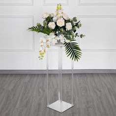 a vase filled with white flowers on top of a wooden floor