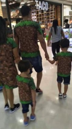 a man and two children are walking through the mall