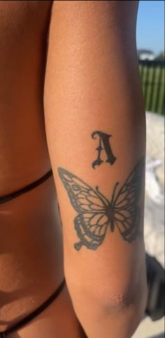 a woman's arm with a butterfly tattoo on the left side of her body