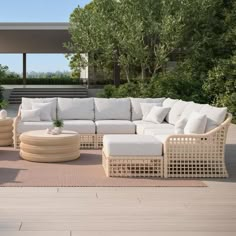 a large white couch sitting on top of a wooden floor next to a table and chairs