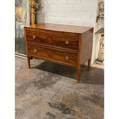 a wooden dresser sitting in front of a white brick wall