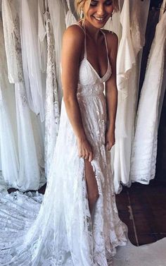 a woman in a white dress standing next to a rack of dresses