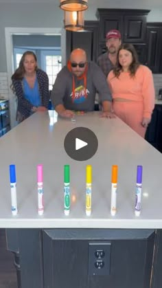 a group of people standing around a table with crayons on top of it