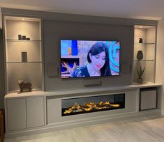 a flat screen tv mounted to the side of a wall next to a fire place