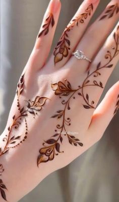 a woman's hand is decorated with hennap and gold flowers on it