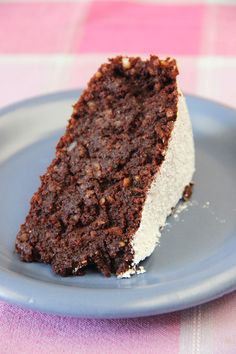 a piece of chocolate cake on a blue plate with a pink and white checkered tablecloth