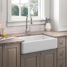 a white kitchen sink sitting under a window