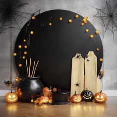 halloween decorations with carved pumpkins and candles in front of a black circle on a wooden floor