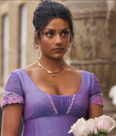 a woman in a purple dress holding a flower and looking off to the side with her hand on her hip