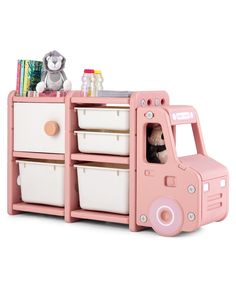 a pink toy truck with two white baskets and a teddy bear