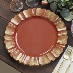 a brown plate sitting on top of a wooden table next to silverware and flowers