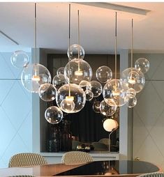 a dining room table and chairs with large bubbles hanging from the chandelier above it