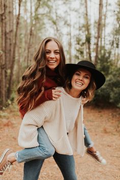 two women in hats and sweaters are posing for the camera while holding each other