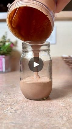 a person is pouring something into a jar