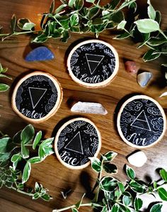 three wooden coasters sitting on top of a table next to plants