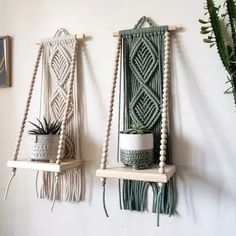 two macrame wall hangings with plants on them