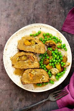 a white plate topped with meat and peas