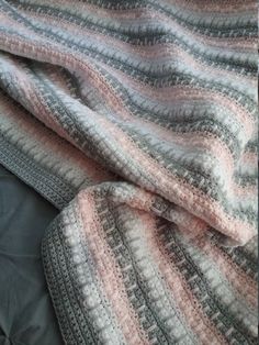 a crocheted blanket laying on top of a bed