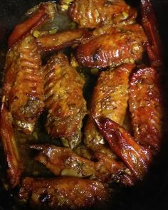 some chicken wings are cooking in a pan