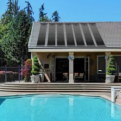 a house with a pool in front of it and steps leading up to the back door