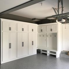 an empty garage with white cabinets and gray flooring