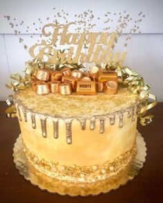 a birthday cake is decorated with gold and silver confetti on the top tier