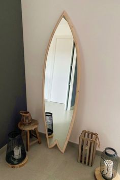 a mirror sitting on top of a wooden shelf next to a lamp and other items