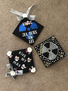 three decorated graduation caps laying on the floor