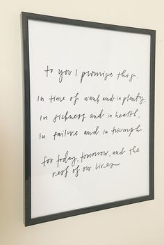 a black and white frame with writing on it hanging on the wall next to a clock