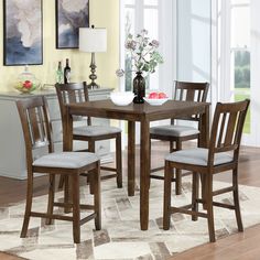 a dining room table with four chairs around it