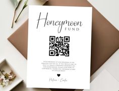 a white card with a qr code on it next to flowers and other items