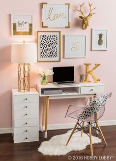 a white desk topped with a laptop computer sitting next to a wall covered in pictures