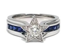 a white gold ring with blue sapphires and a star in the center, on a white background