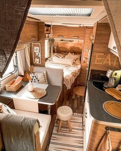 the inside of a camper with two beds and a kitchenette in front of it