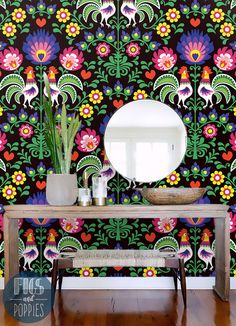 a table with a mirror on top of it in front of a colorful wallpaper